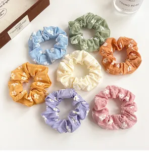 Flat lay of 7-piece floral scrunchie set in pastel colors with soft wrinkled texture