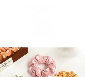 Close-up of colorful floral scrunchies in pink and yellow with soft textured fabric