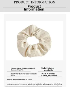 Detail view of a beige pleated scrunchie with rhinestones, 12cm diameter cloth accessory