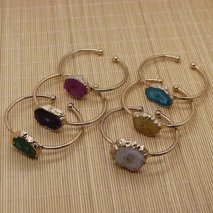 Détail de six bracelets dorés ajustables avec des pierres naturelles brutes de géode