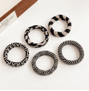 Set of five knitted elastic hair ties with black and beige striped patterns and zebra prints