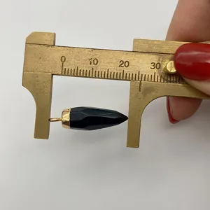 Macro-opname van 22,5mm zwart gefacetteerde kegelhanger met een gouden sluiting