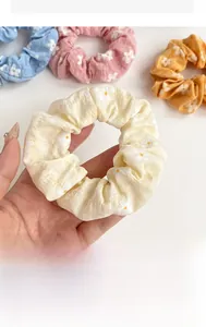 Close-up of floral print hair scrunchies in pastel colors showing soft fabric texture