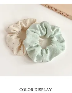 Detail of cream and mint green scrunchies with sparkling silver rhinestones and texture