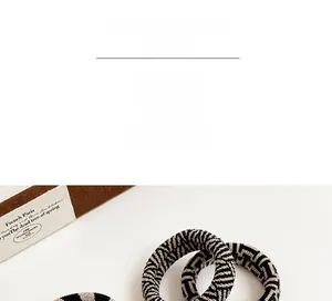 Detailed view of the thick elastic checkered hair tie with durable woven texture