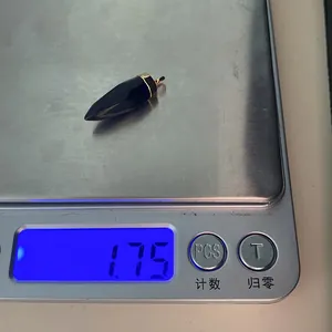 Gewichtsmeting van een zwarte natuurstenen hanger in de vorm van een kogel