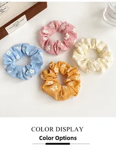 Floral print scrunchie set in pastel colors shown with elegant lifestyle accessories