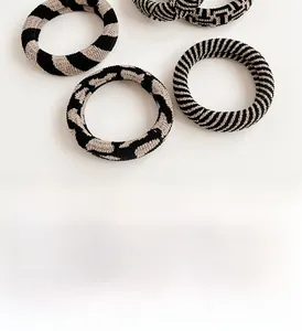 Close-up of thick checkered hair scrunchie with elastic knit texture and zebra pattern