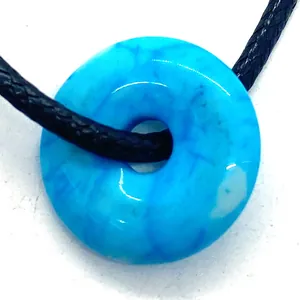 Detailed macro of natural blue snowflake stone donut pendant with black braided rope