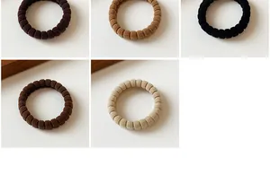 Detail of high-elasticity hair ties in five earth-toned colors and ribbed fabric texture
