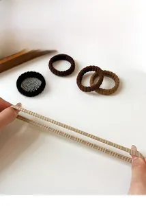 Close-up of elastic ribbed hair ties in earthy tones showing texture and stretch
