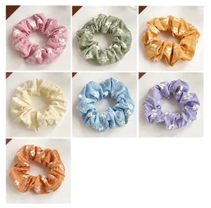 Detailed grid view of 7 colorful floral scrunchies with soft cotton linen texture