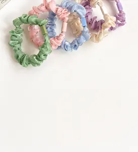 Détail des strass colorés sur chouchous élastiques aux tons pastels doux