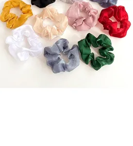 Gros plan de chouchous en organza colorés montrant le tissu brillant et la texture élastique