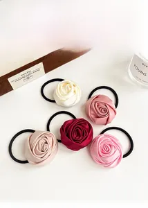 Close-up of five satin rose hair ties in beige, pink, champagne, burgundy and hot pink