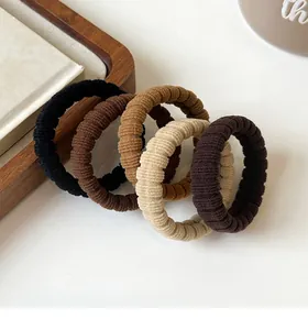 Detailed texture of five high-elasticity ribbed hair ties in earthy neutral tones