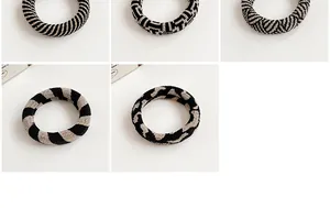 Macro detail of various knitted checkerboard hair ties in black and white patterns