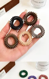 Gros plan d'élastiques à cheveux spirales mats aux tons terreux marron et beige