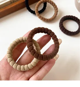 Detailed view of elastic ribbed hair ties in coffee tones with textured knit material