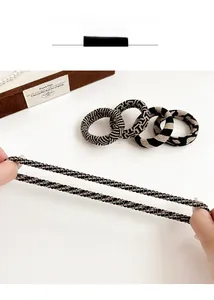 Detail of four checkered and leopard print knit hair ties with high elasticity display