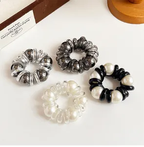 Detailed view of four pearl and metallic spiral telephone wire hair ties in a gift box