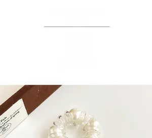Close-up of spiral telephone wire hair tie with embedded pearls and elastic structure