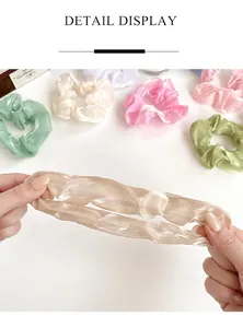 Gros plan de chouchous en organza perlé haute élasticité montrant l'élasticité et le tissu