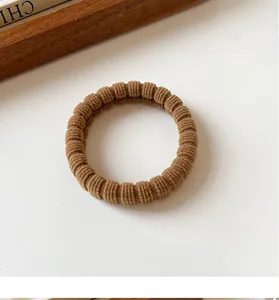 Detailed view of the ribbed texture and high elasticity of the coffee-colored hair tie