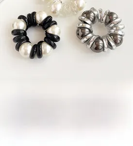 Detailed view of spiral telephone cord hair ties with decorative pearl accents in three colors
