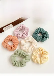 Detailed view of six elastic scrunchies in soft Morandi colors with crinkle texture