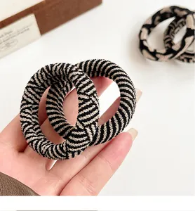 Close-up of durable black and beige checkered elastic hair ties with high-density knit texture