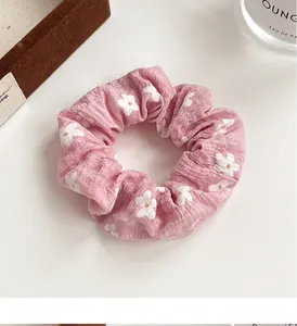 Detail of pink floral scrunchie with white daisy prints on soft crinkled cotton fabric