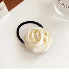 Detailed view of 3D cream satin rose hair scrunchie with durable black elastic band