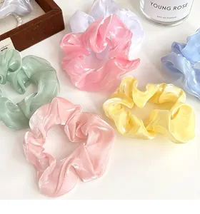 Détail d'élastiques à cheveux en tissu nacré aux couleurs pastel assorties