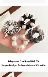 Detail showing four styles of pearl telephone wire hair rings in metallic and neutral colors