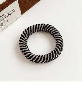 Macro view of checkered spiral hair tie with thick knit texture and elastic band