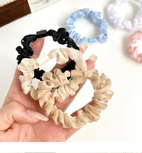 Détail de chouchous en satin avec perles scintillantes et attaches colorées en tons pastel