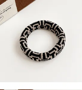 Macro shot of durable checkerboard woven hair scrunchie with elastic geometric texture