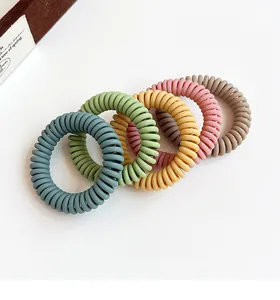Detail of five Morandi color spiral hair ties in matte finish on white background