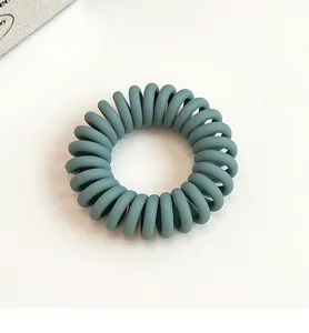 Détail macro de l'élastique à cheveux en spirale bleu Morandi mat avec texture sans couture