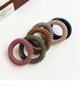 Detailed view of six matte Morandi colored spiral hair ties in a diagonal arrangement