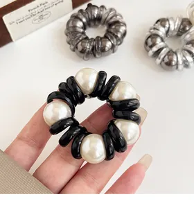Detailed view of spiral telephone cord hair tie with elegant white lustrous pearls
