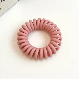 Vue détaillée de l'élastique à cheveux spirale rose mat avec structure sans couture