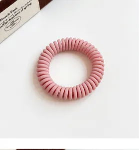 Detail shot of a matte dusty pink spiral telephone wire hair tie with a flexible design