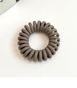 Gros plan sur l'élastique à cheveux spirale marron mat en résine extensible