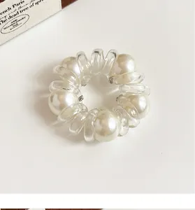 Detail of spiral hair tie featuring elegant pearls and high-elastic transparent design