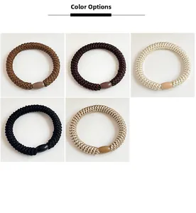 Close-up of five neutral-toned braided hair ties with matching oval resin buckles