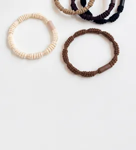 Close-up of high-elasticity braided hair ties in beige, brown, and black tones