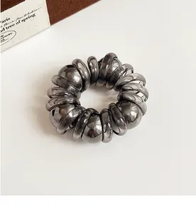 Detailed view of grey pearl spiral hair ring with metallic finish on white background