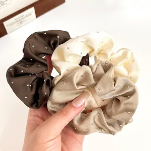 Trois chouchous élégants en satin avec strass en couleurs café, champagne et crème
